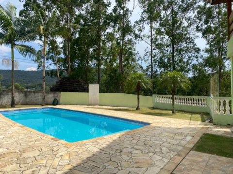 Piscina cercada por árvores verdes.