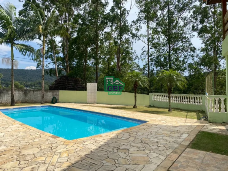 Piscina cercada por árvores verdes.