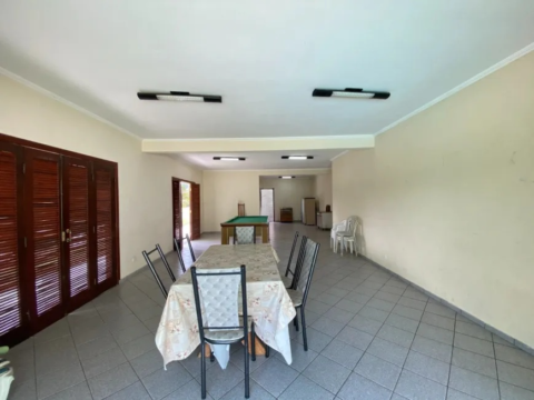 Sala ampla com mesa e cadeiras.