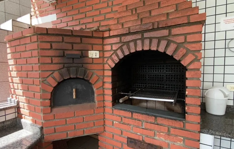 Churrasqueira em área gourmet de tijolos